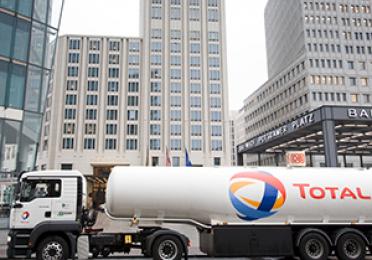 Weisser TotalEnergies Heizöl Tankwagen&nbsp;vor Hochhäusern

