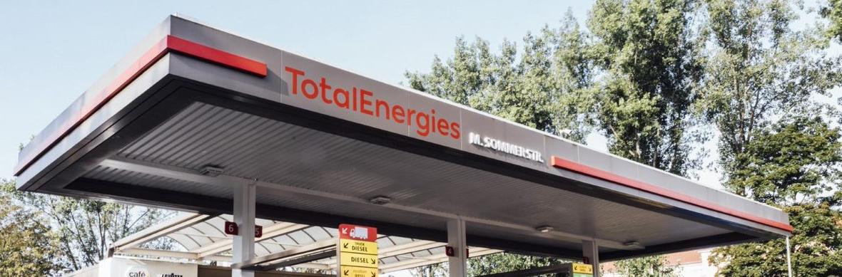 Schrägansicht auf TotalEnergies Tankstelle mit Schriftzug auf dem Dach
